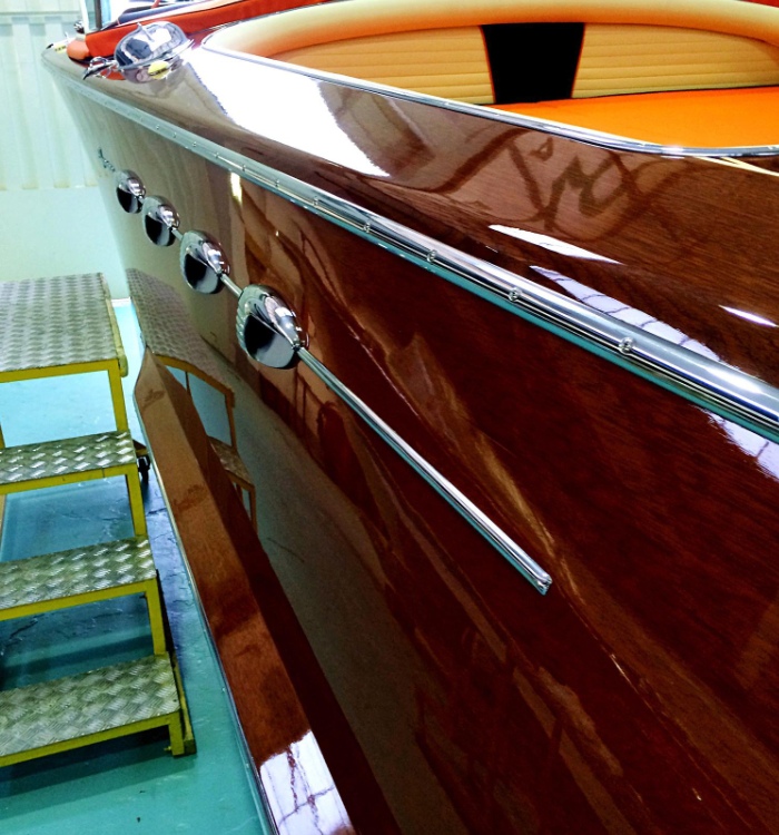 Finition brillante sur coque de bateau en bois verni